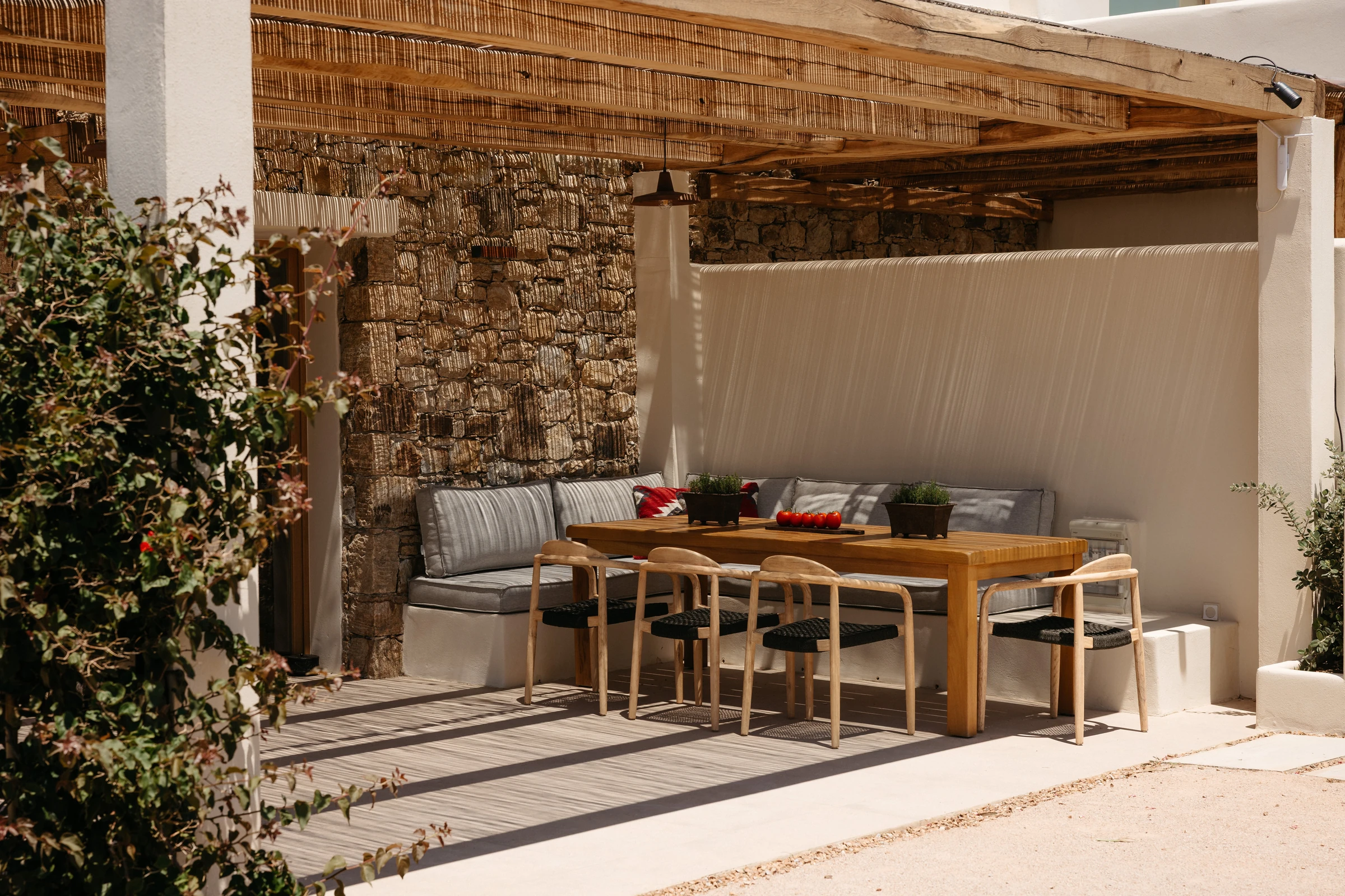 A shaded dining nook against the stone wall