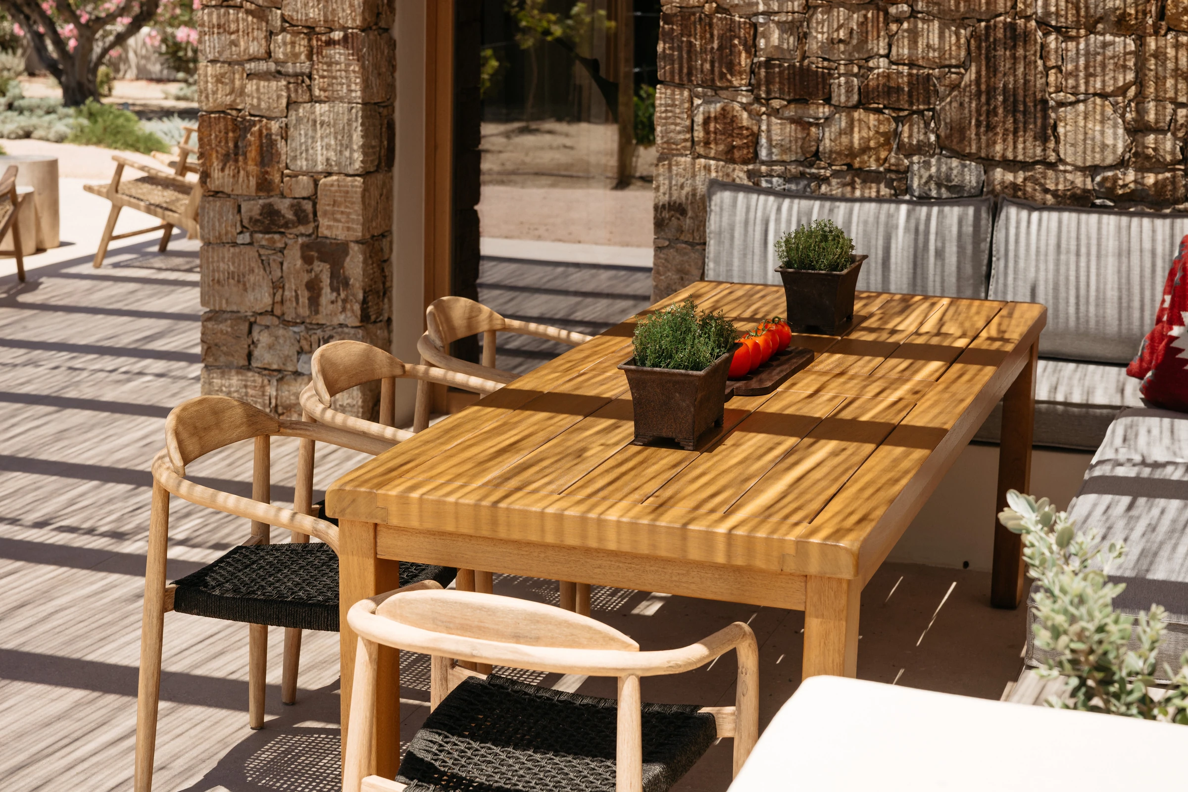 The teak table with herbs and tomatoes in the light