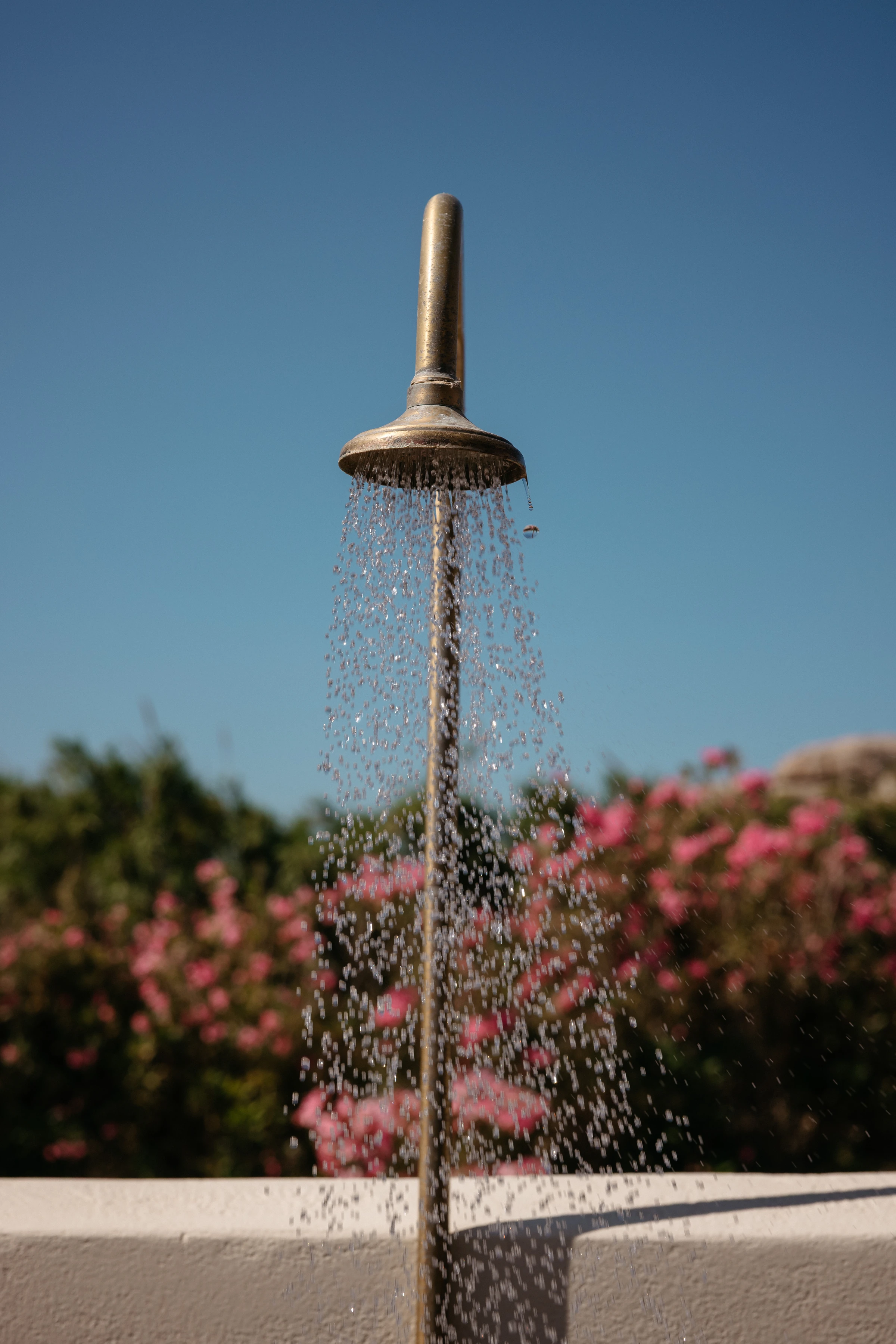 The brass shower running against the sky