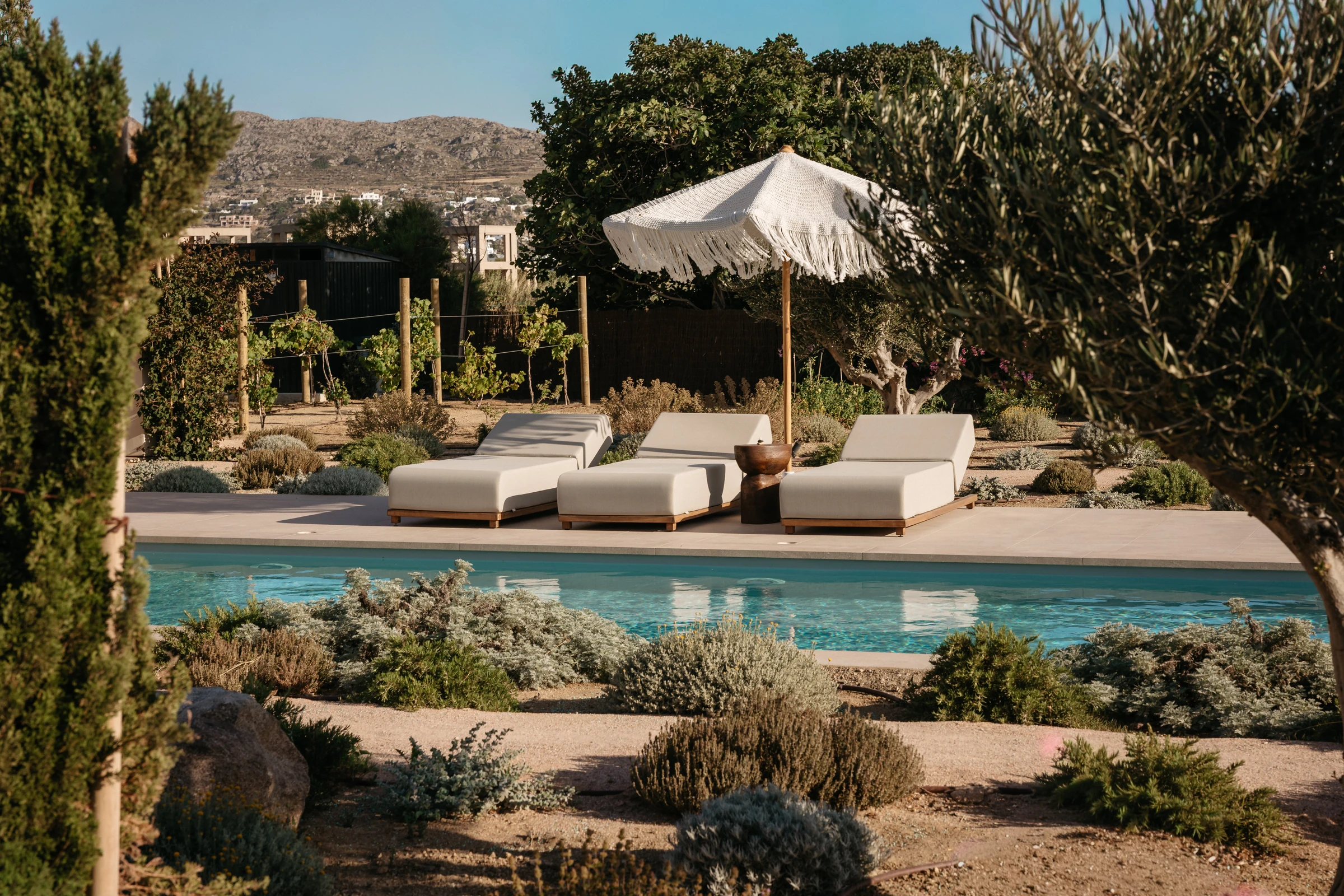 Loungers under a fringed parasol by the water