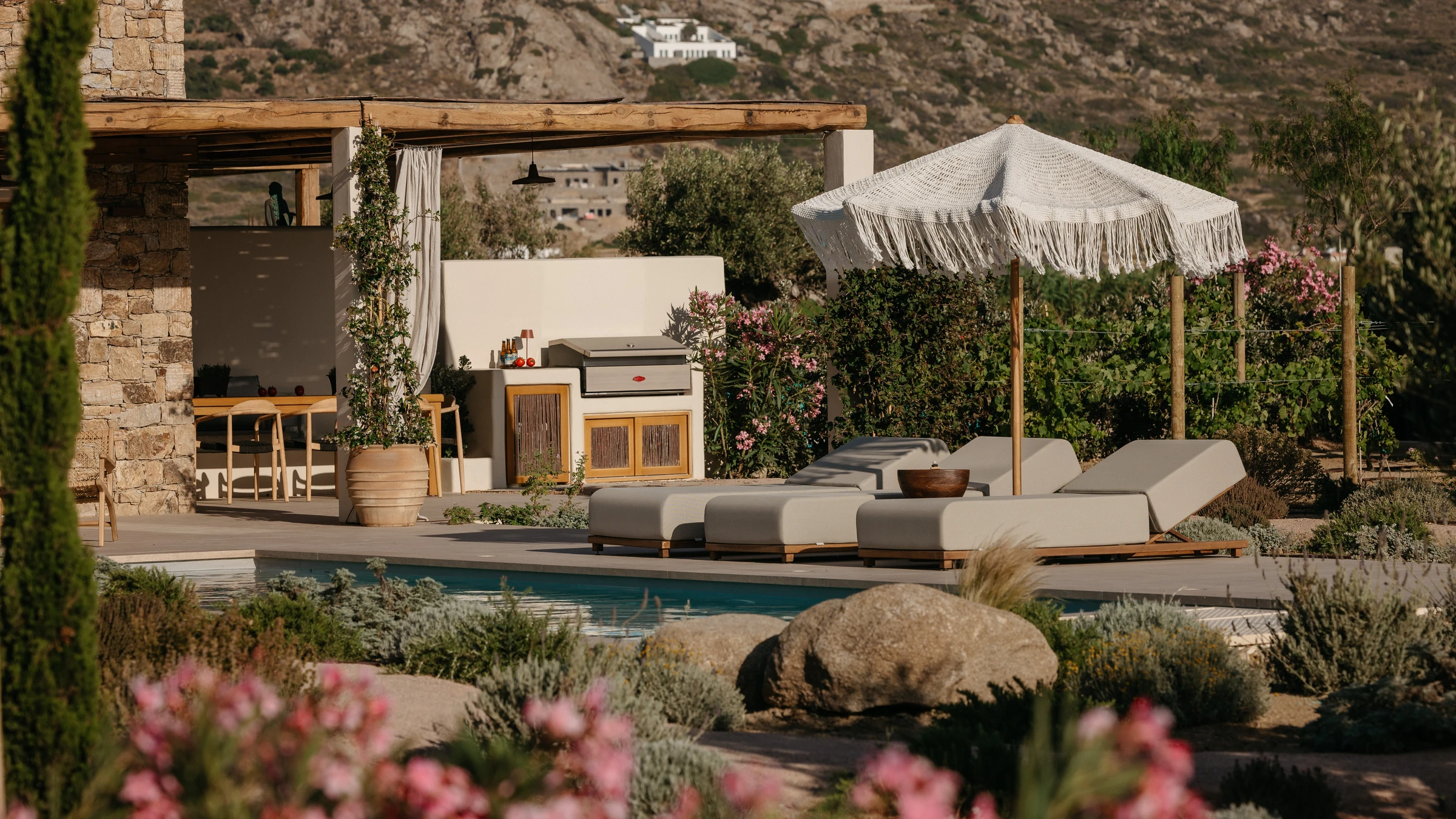 The pool, loungers and terrace at golden hour