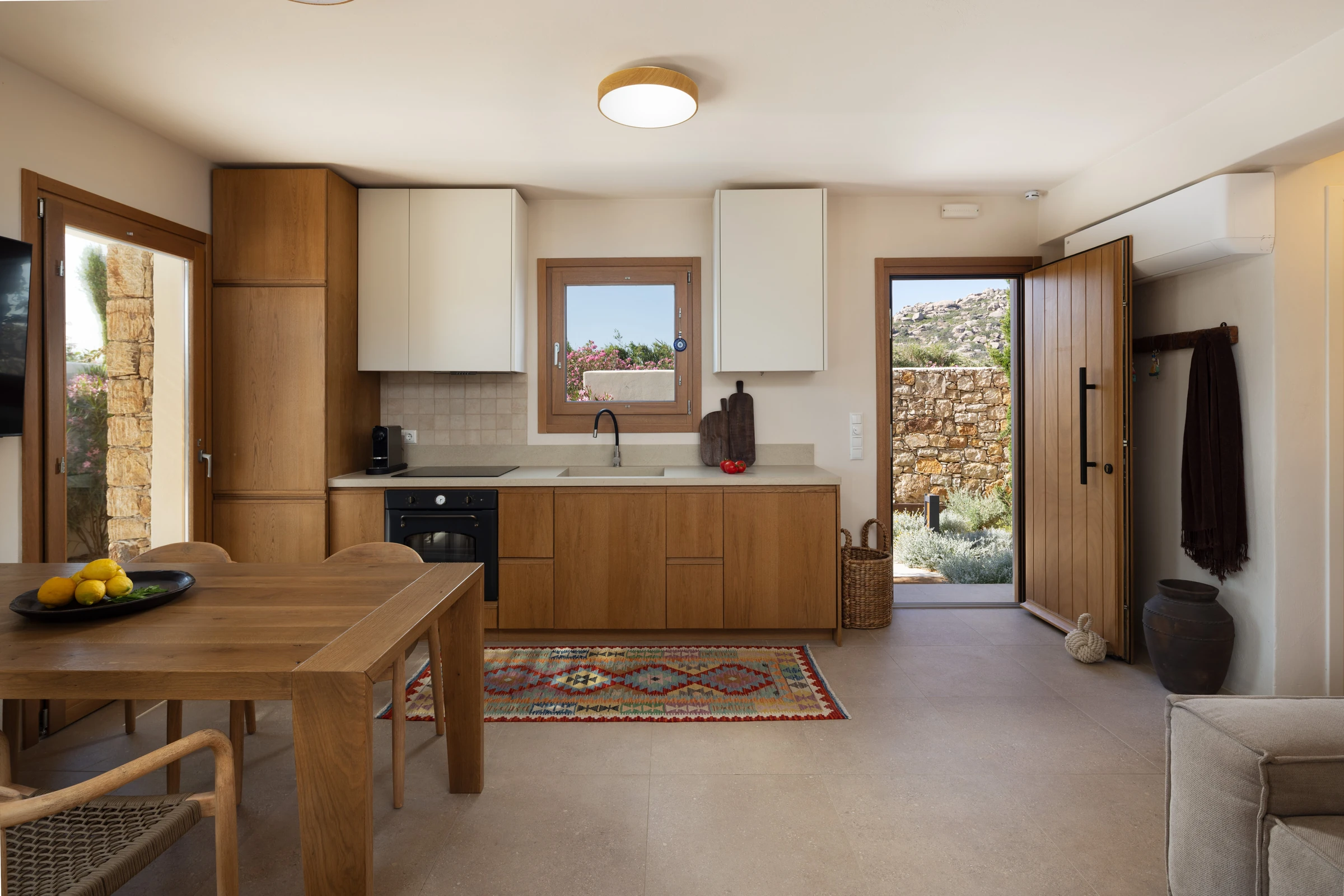 Timber kitchen run with window over the sink and open garden door