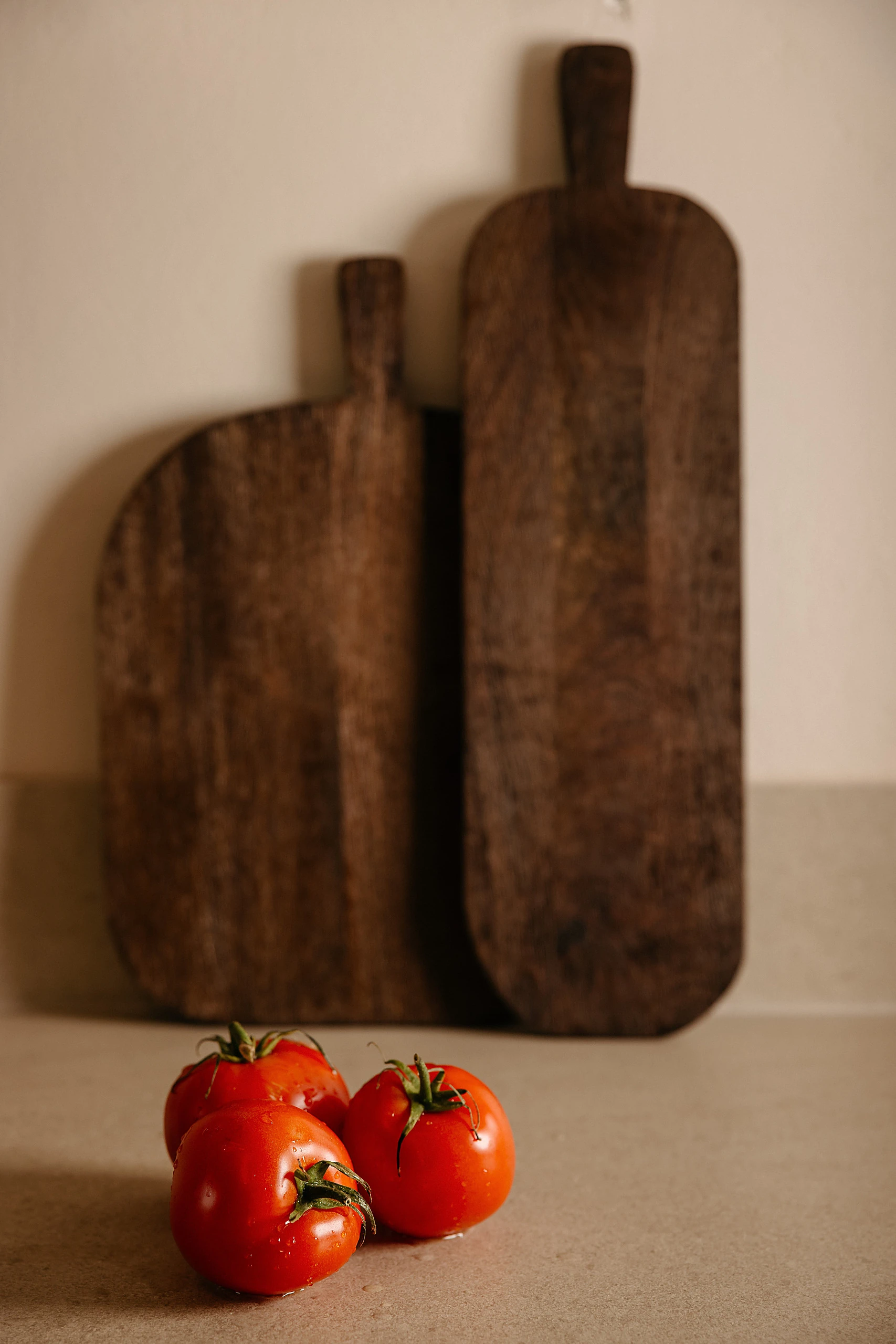 Carved wooden boards and tomatoes on the counter
