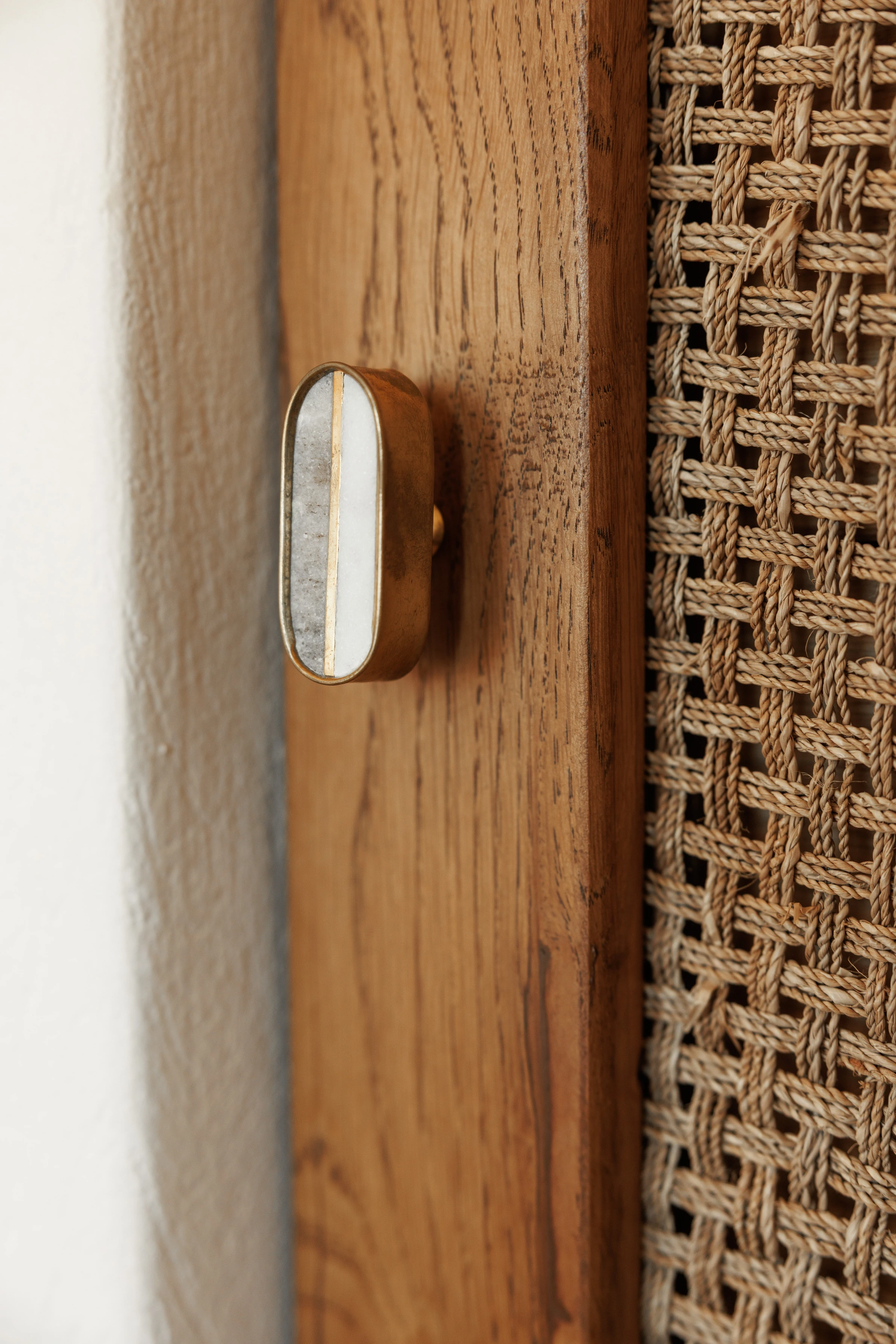 A brass-and-marble knob on the caned wardrobe door